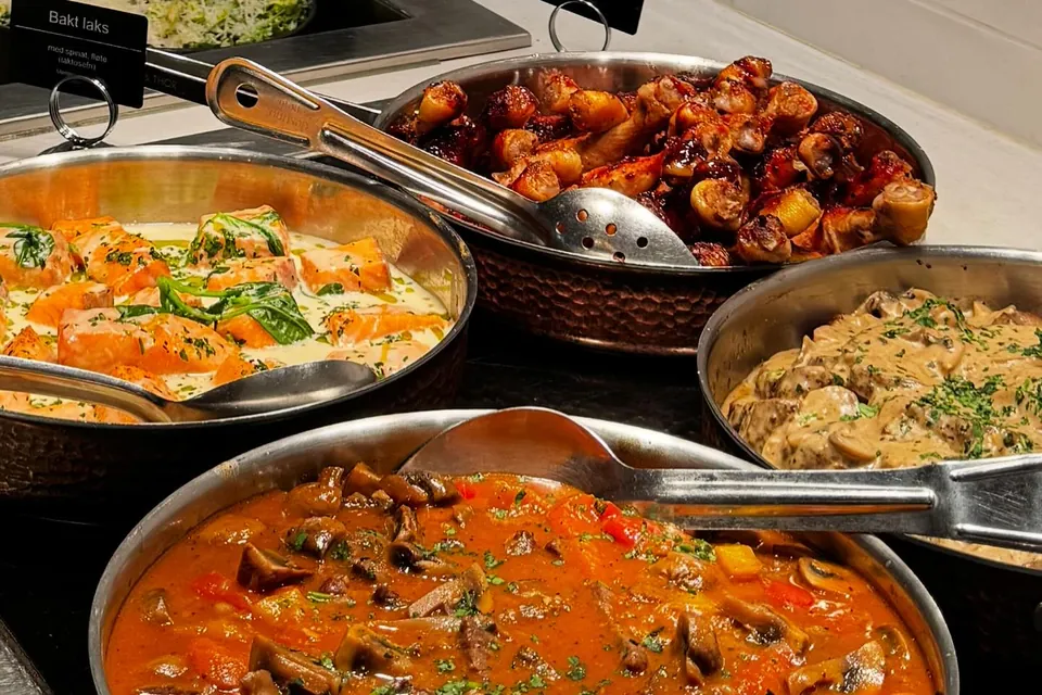 Gryter med bakt laks, kyllinglår og varme retter på lunsjbuffeen hos Erica mat & vinbar
